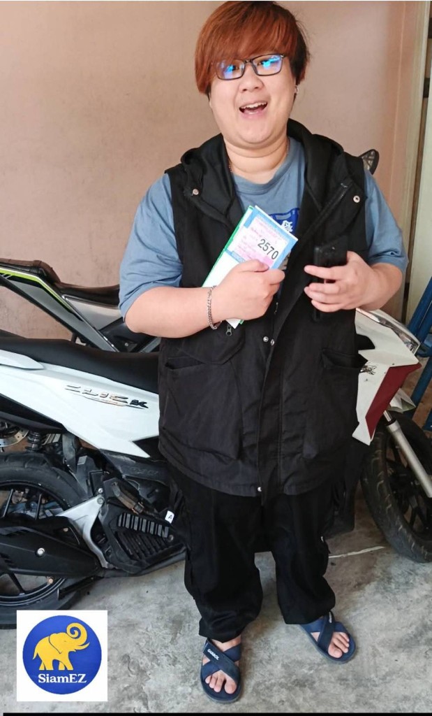 Customer with Thai vehicle tax sticker for year 2570 next to a white Honda Click motorcycle
