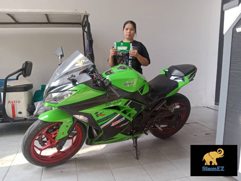 Customer with green registration card next to a lime green Kawasaki Ninja motorcycle